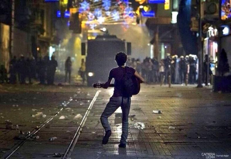 A Turkish protestor plays guitar for police [Turkey, 2011]