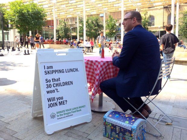 Portland man skips his lunch to raise money, awareness for Oregon Food Bank Anton Cobb, 32, sits alone in Director's Park during his lunch hour every Wednesday at a table decorated with a red and white checkered tablecloth. 